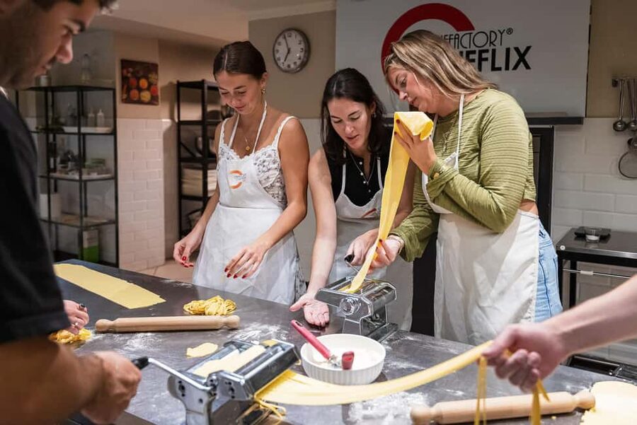 Florence: Handmade Pasta & Dessert Class with Unlimited Wine - Rolling dough by hand and using the pasta machine